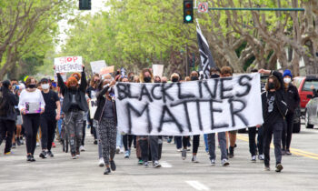Alameda, CA - Apr 24, 2021: Unidentified participants holding signs at a youth lead End Police Brutality March marching from Washington Park to Alameda Police Station for a rally.