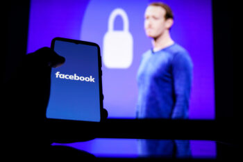 Facebook logo on screen and Mark Zuckerberg is a Chief Executive Officer of Facebook in background