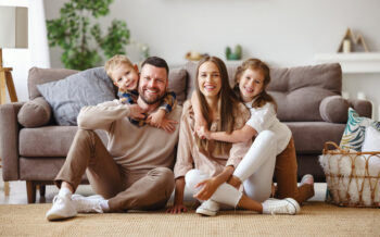 happy family mother father and children at home on the couch